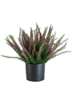 The Artificial Plant Erica 33 cm is an upright artificial plant in a black pot, with bushy green leaves and numerous long stems decorated with small purple and pink flowers that spread outwards.