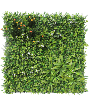 The Artificial Hedge Lucia 100x100 cm UV has a vertical garden wall with dense green foliage, small white flowers, vibrant clusters of yellow and orange flowers at the top left and long pointed leaves at the bottom right.