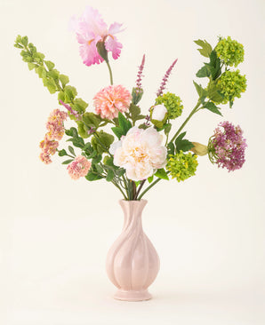 The First Light silk artificial flower bouquet features white, pink, green and purple flowers with green petioles in a pastel pink vase - an elegant accent for any room.