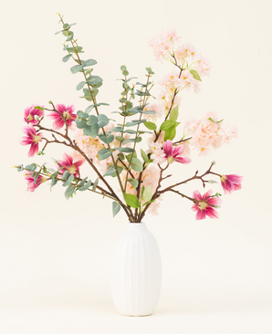 In a vase with a white structure is the Featherlight Florals silk artificial flower bouquet with soft pink and deep magenta silk flowers, plus green eucalyptus leaves on long stems, against a light background.