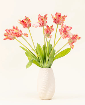 A vase with a white structure shows the Silk artificial flower bouquet French Parakeet Tulip red/yellow, with lifelike red and yellow tulips with green leaves against a plain light background.