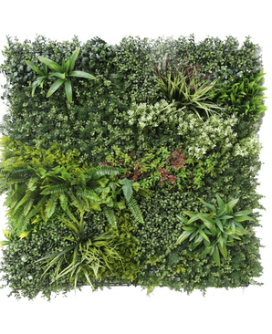 The Artificial Hedge Prestige 100x100 cm UV is a square panel of artificial green foliage with mixed leafy plants, ferns, varied textures and shades of green, plus clusters of small white and red flowers. The background is white.
