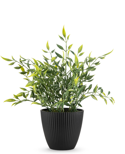 Een Kunstplant Bamboe 28 cm, een bladgroene potplant met lange, slanke bladeren, sommige met een gele punt, groeit in een verticaal geribbelde zwarte pot tegen een effen witte achtergrond.