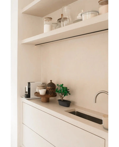Minimalist countertop with a small sink, decorative pots, a coffee maker and bins on floating shelves. In the neutral white-beige color scheme, the Artificial Bonsai Ficus 30 cm is used as an accent pot plant.