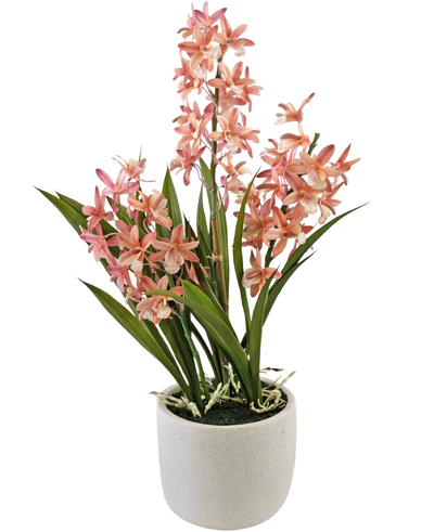 De Kunstplant Cymbidium 58 cm roze heeft hoge groene bladeren en trossen roze en witte orchideeënbloemen, gerangschikt in een eenvoudige pot van wit keramiek, perfect om elke ruimte op te fleuren.