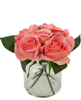 The Artificial Rose Bouquet Real Touch Pink 18cm has small pink artificial roses with green leaves in a clear glass jar against a white background.