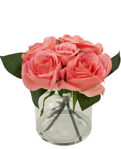 The Artificial Rose Bouquet Real Touch Pink 18cm has small pink artificial roses with green leaves in a clear glass jar against a white background.