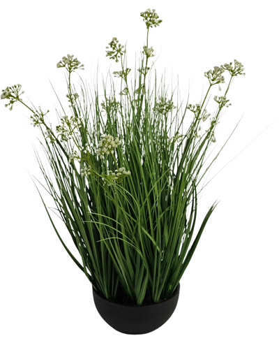 De Kunstgras Prei Bloem Ui Graspot 60cm brandvertragend heeft hoge, dunne grasachtige groene bladeren met kleine witte bloemtrosjes in een zwarte pot, tegen een witte achtergrond.