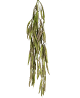De Kunst hangplant Aloë Vera 102 cm heeft lange, smalle groene bladeren met gekartelde randen die naar beneden vallen tegen een effen witte achtergrond.