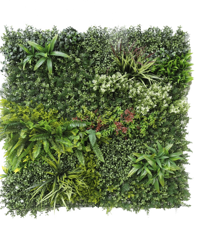 The Artificial Hedge Prestige 100x100 cm UV is a square panel of artificial green foliage with mixed leafy plants, ferns, varied textures and shades of green, plus clusters of small white and red flowers. The background is white.